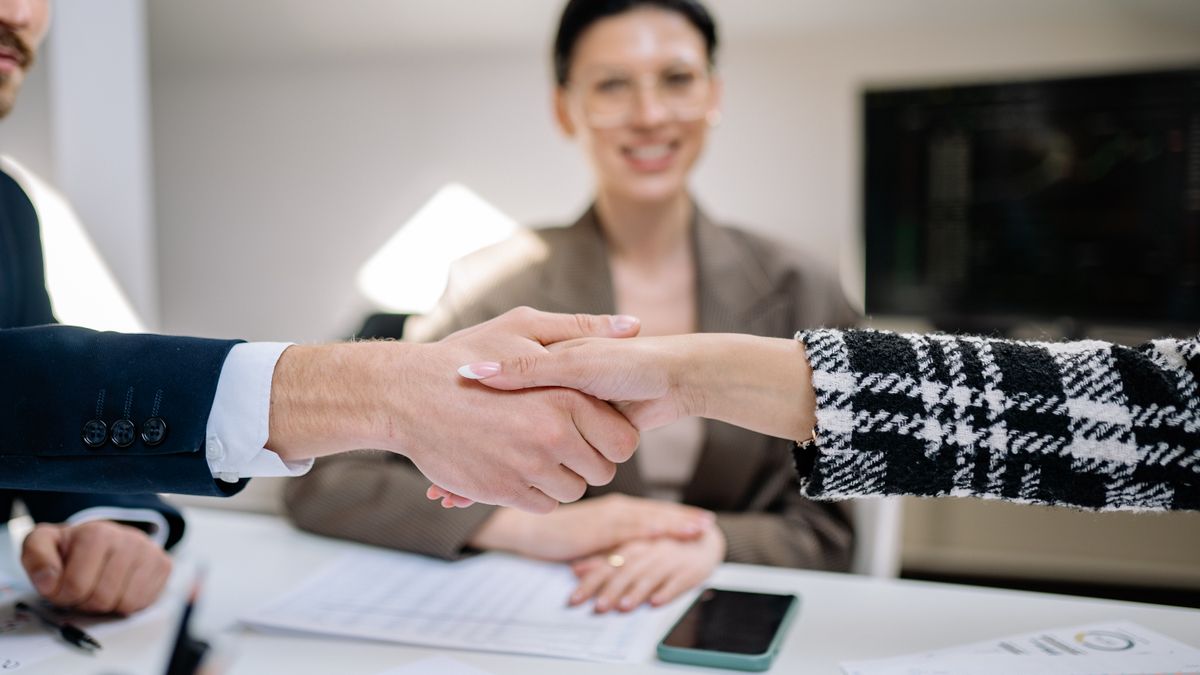 Apretón de manos entre un abogado y su cliente. ¿Cómo explicarle a un cliente su proceso sin perderlo en tecnicismos? — Compuasociados.